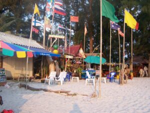 Flags of many countries in front of food and drink stands on a beach